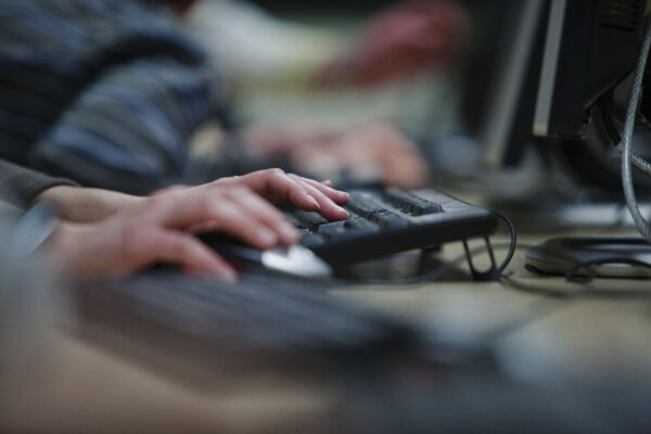 Mains qui tapent sur un clavier d'ordinateur