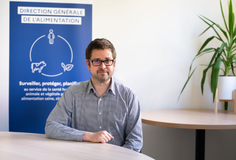 Photo de l'agent accoudé à une table dans son bureau